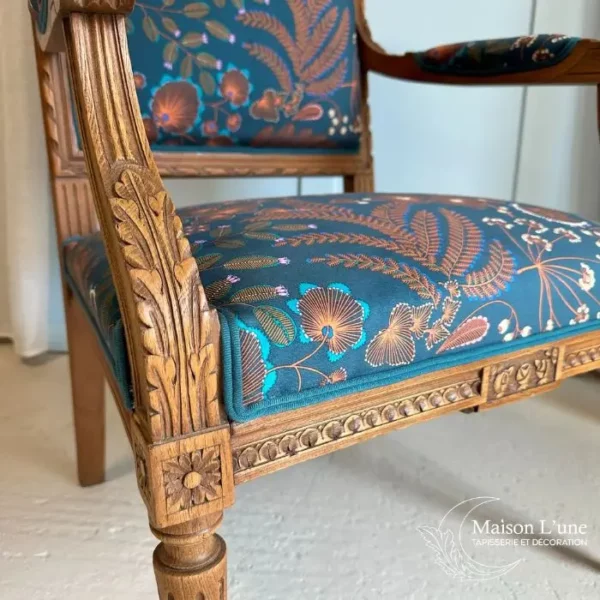 Fauteuil style Louis XVI au motif végétal marron sur fond bleu pétrole.