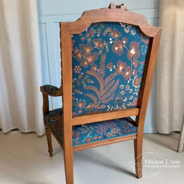 Fauteuil style Louis XVI au motif végétal couleur cognac sur fond bleu pétrole.